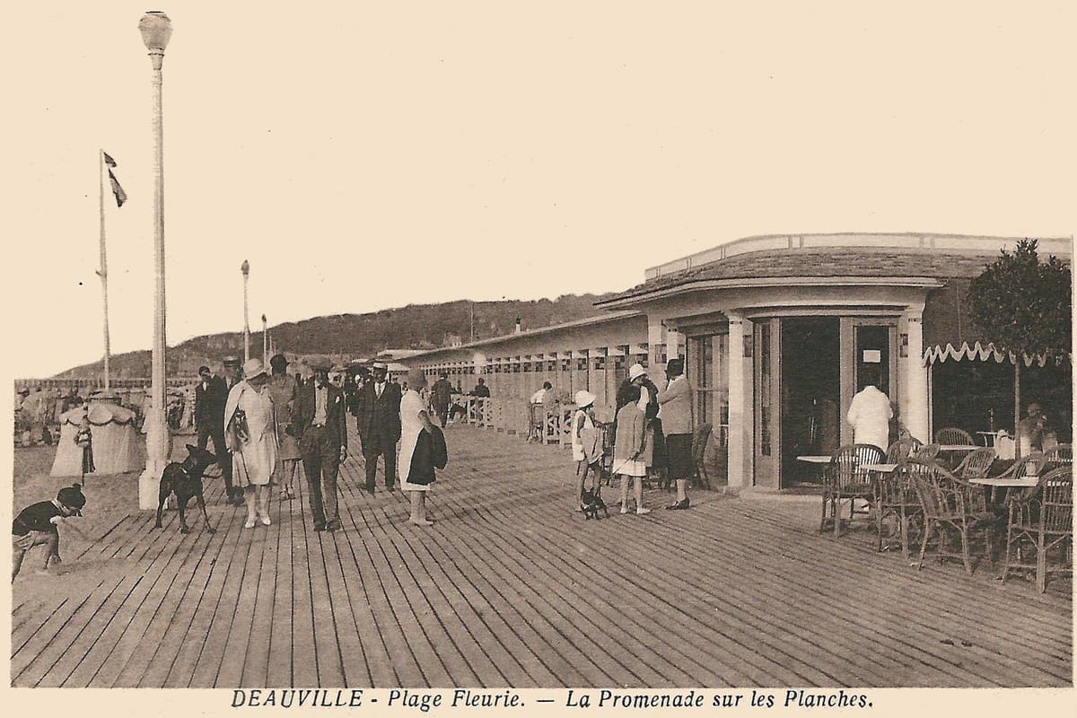 Carte postale ancienne sépia : des promeneurs sur une promenade en planches, devant un pavillon à colonnes et des cabines.